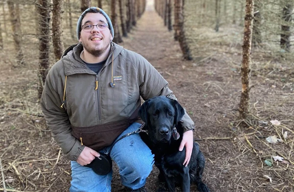 A young man posing with a dog